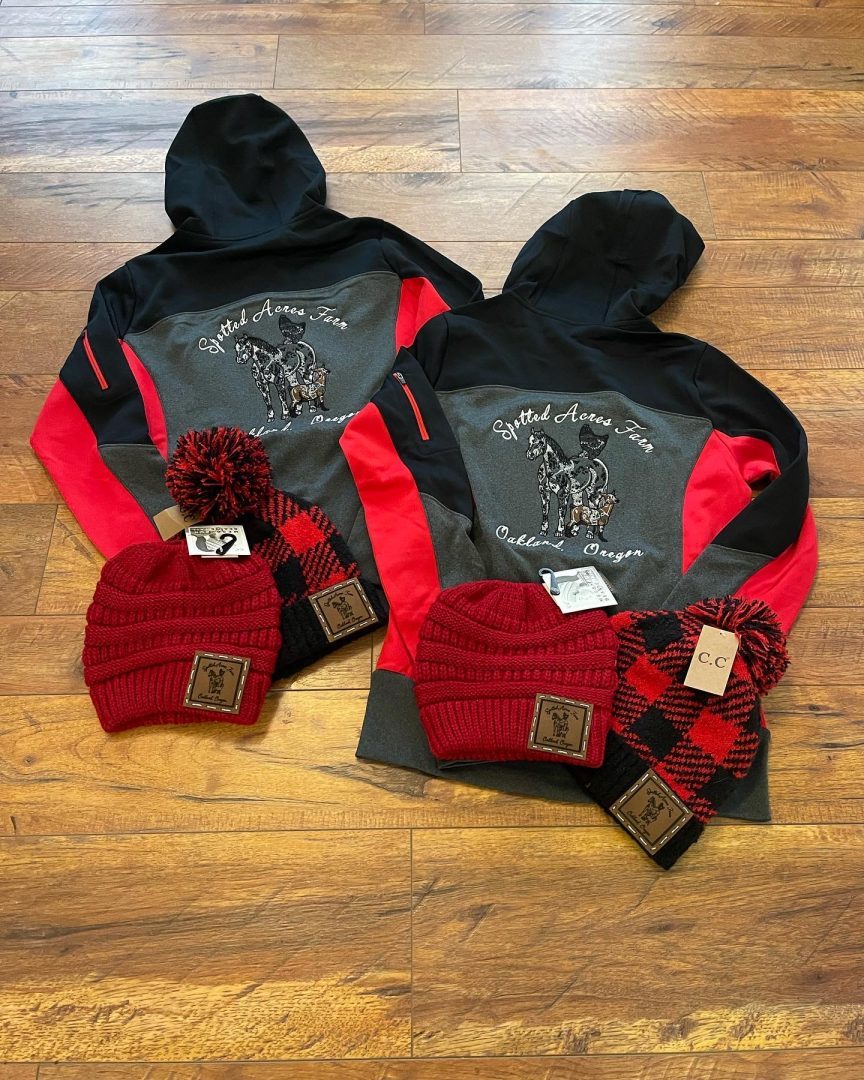Black and red athletic hoodies with embroidered Spotted Acres Farm Oakland Oregon horse logo and matching CC beanies