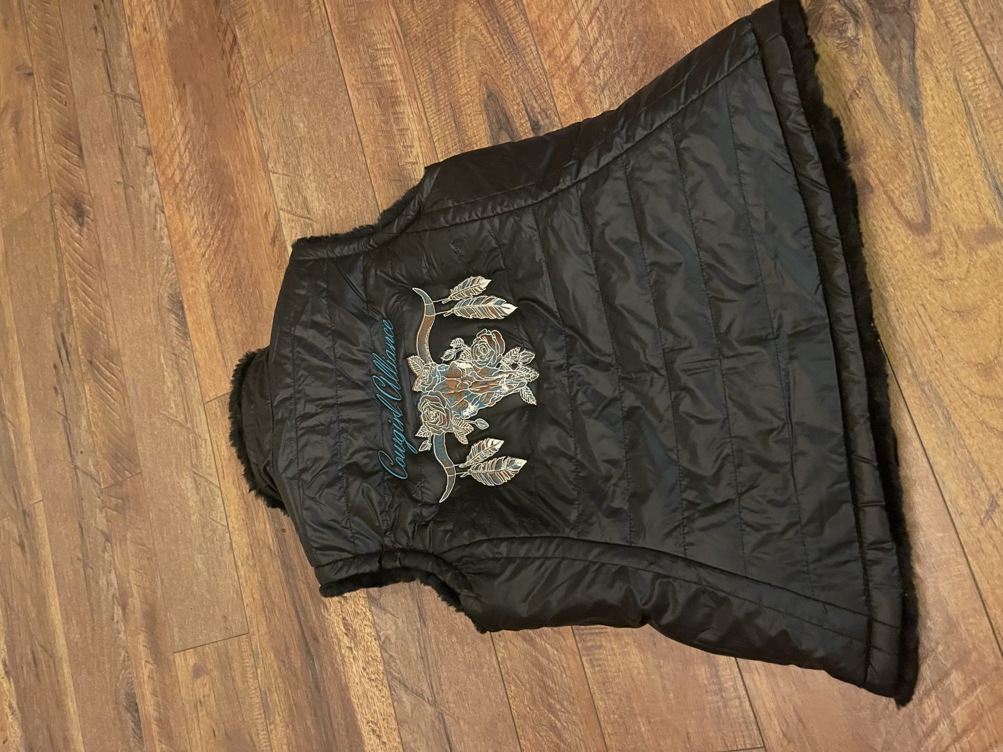 Black quilted vest with fur trim embroidered with Cowgirl Alliance roses and arrows design