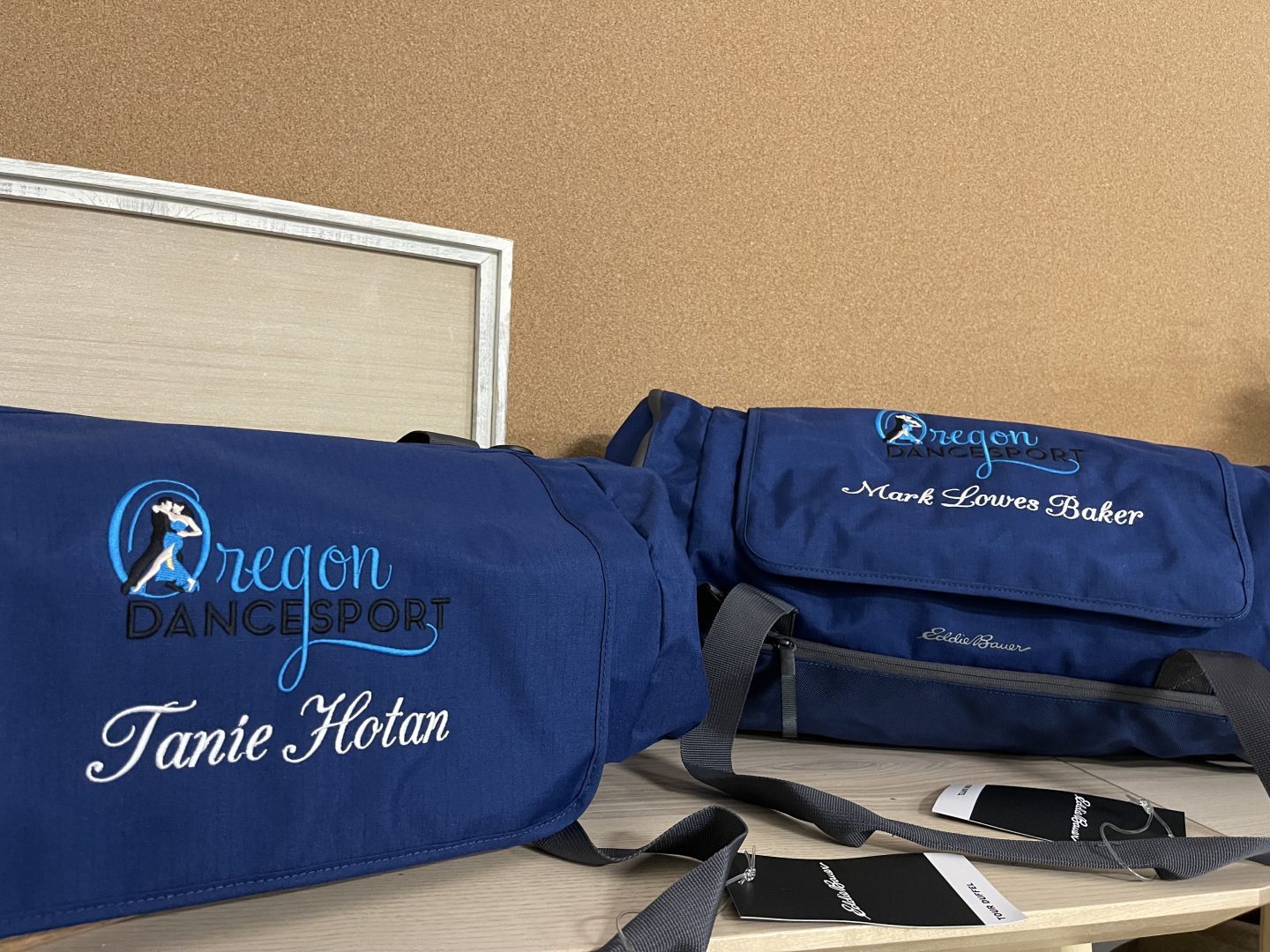Navy blue embroidered Eddie Bauer duffel bags with Oregon Dancesport logo and personalized names