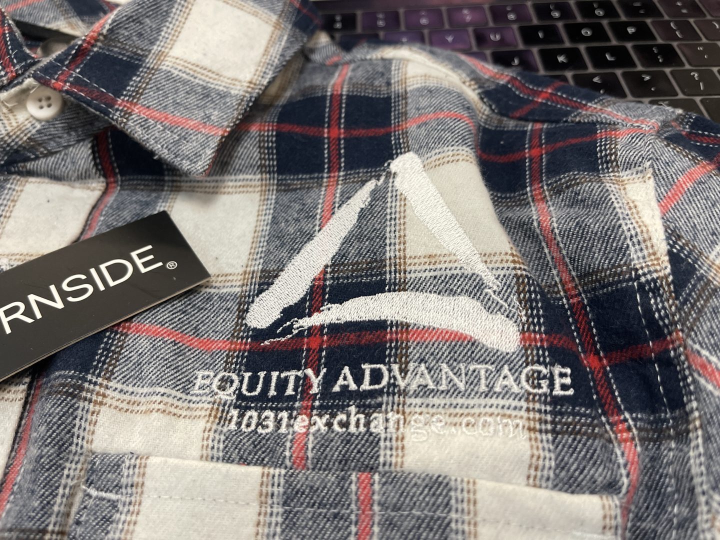 Plaid Burnside flannel shirt with embroidered Equity Advantage 1031 exchange company logo