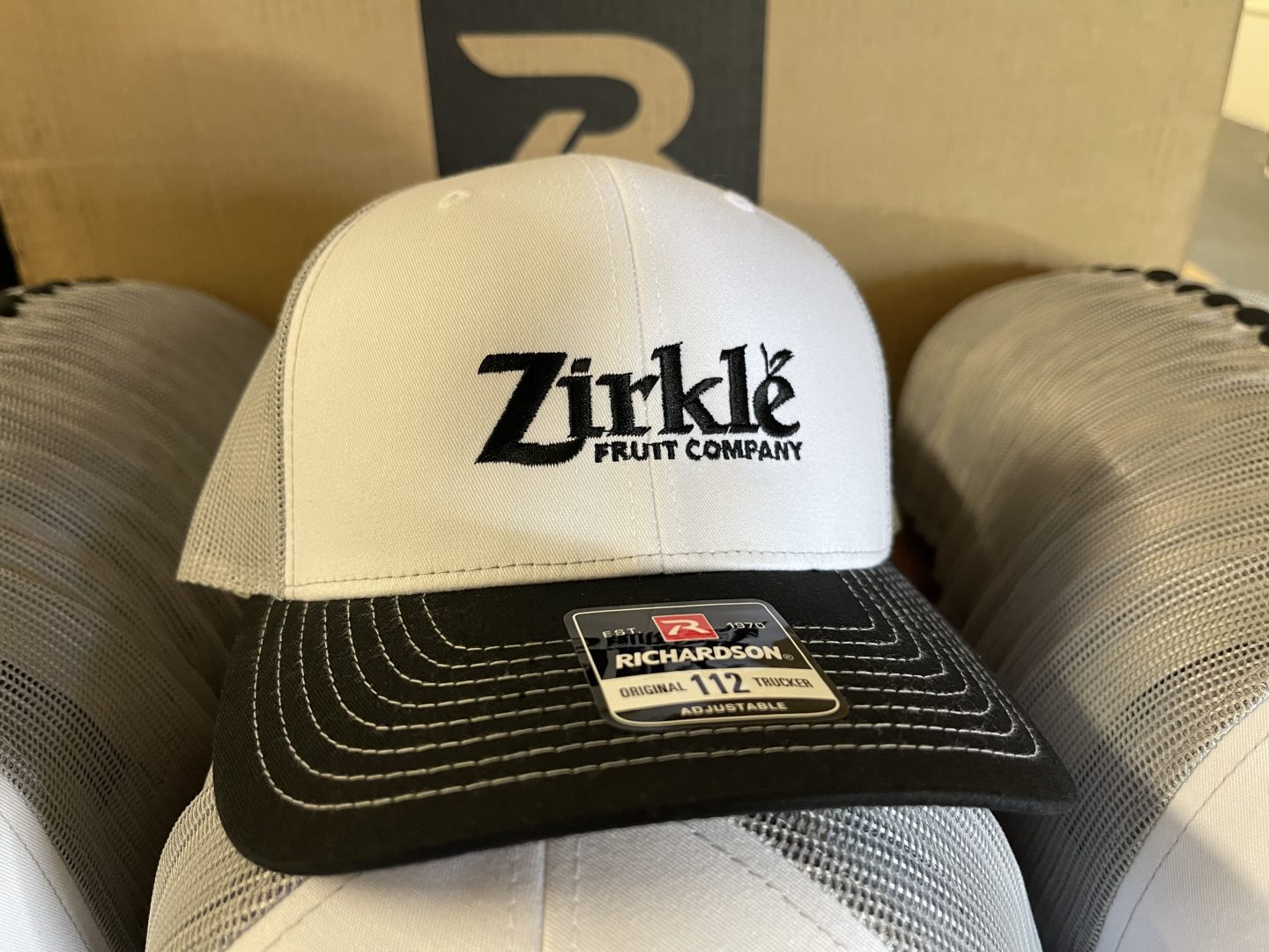 White Richardson trucker hat with embroidered Zirkle Fruit Company logo and black bill