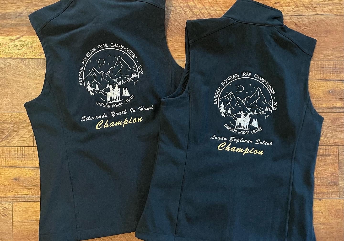 Black vests with embroidered National Mountain Trail Championship Oregon Horse Center champion award