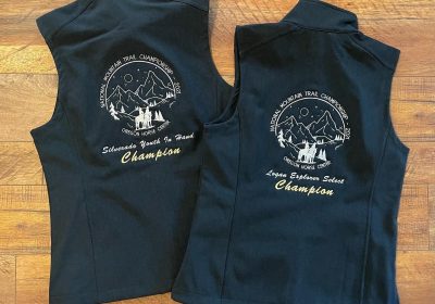 Black vests with embroidered National Mountain Trail Championship Oregon Horse Center champion award