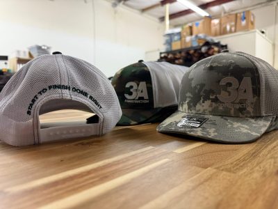 Richardson trucker hats in woodland and digital camo with embroidered 3A Construction logo front and back