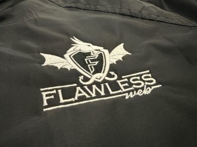 Black jacket with embroidered Flawless Web company logo featuring dragon with shield and wings