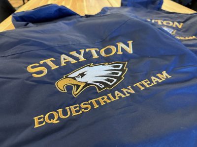 Blue windbreaker jackets with embroidered Stayton Equestrian Team eagle mascot logo in gold