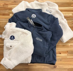 Embroidered corporate apparel Allium Financial Advisors heather blue quarter zip and cream sherpa fleece jackets